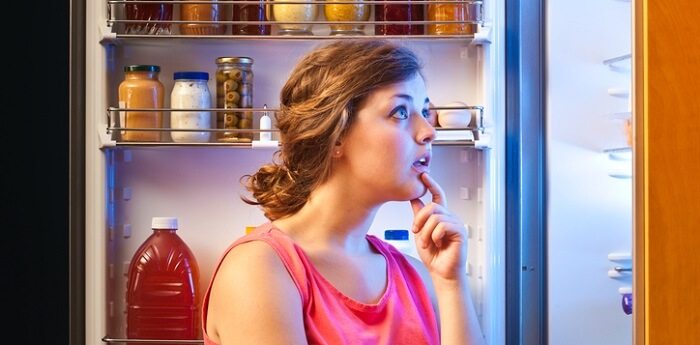 woman looking for something to eat in refrigerator
