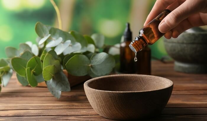 pouring essential oils for inflammation blend into bowl